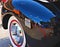 Downtown Sapulpa Oklahoma reflected in the black fender of a restored automobile. Blue sky above. At an auto show on Route 66.