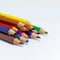 a dozen colored pencils on a white background