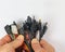 A dozen different plugs for electronic devices in men`s hands