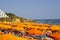 Dozens of brightly coloured sun beds and beach umbrellas on the sandy Praia Da Oura beach in Alubferia in Portugal