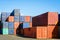 Dozens of multicolored dry cargo containers stacked in an intermodal port terminal