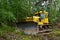 Dozer during clearing forest for construction new road . Yellow Bulldozer at forestry work Earth-moving equipment at road work,