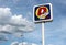 DpiÃ¹ logo on a pole outside a store of the town against a blue cloudy sky. It is a large italian discount supermarket chain.