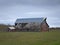 Drab Abandoned Dilapidated Farm Barn and Shed with clouds