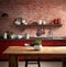 of a drab kitchen with red brick walls and a wooden table