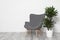 Dracaena and chair at white brick wall. Plants in trendy home interior design