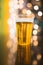 Draft beer in plastic disposable cup, festive lights background