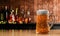 Draft or craft beer in tall clear glass. With cold steam, White beer foam placed on a wooden floor, behind the background is a