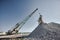 Dragline pours chalk from bucket operating in open quarry