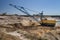 A dragline walking excavator works in a clay quarry