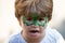 Dragon body art. Child with a mask on his face. Carnival. Favorite hero for a childrens party. Green face and fangs. A