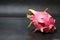 Dragon fruit on the black floor. The shape is spherical. Available in red or purple.