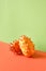 Dragon fruit, pitahaya. Close-up on two fruits on two color paper background. Vibrant orange and mint green vibrant