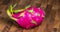 Dragon fruit on a wood table, rotating camera movement around the pink fruit.