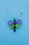 Dragonfly made of beads, children`s crafts on a blue background