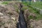 Drainage pipe wrapped in geotextile, inserted into a ditch dug around the house.