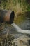 Draining sewage from pipe into river, pollution rivers and ecology