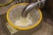 Draining whey from tank into sieve at cheese factory