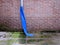 Drainpipe with a blue plastic spout on a red brick wall