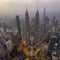 Dramatic aerial photograph of Kuala Lumpur city skyline during hazy sunrise.