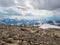 Dramatic alpine landscape with abyss and high mountain range with flying bird under cloudy sky. Colorful scenery with sharp rocks