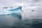 Dramatic Antarctic landscape in Paradise Harbor, Antarctica, with sculptural icebergs and a small inflatable raft cruising in back
