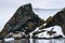 Dramatic Antarctic snow covered and rocky shoreline in Paradise Harbor, Antarctica, with small inflatable rafts cruising in foregr