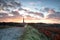 Dramatic beautiful sunrise over lighthouse and sea buckthorns