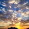 a dramatic beautiful sunset over fields with amazing colorful clouds in sky