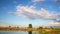 Dramatic blue evening sunset sky over dry grass field at pond lake shore. Rural countryside cloudscape over dry autumn