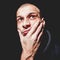 Dramatic close up portrait of young bald man with hand on his face looking up not isolated on black background