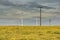 Dramatic cloud sky over cornfield with dark rain clouds and power lines and wind turbines