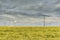 Dramatic cloud sky over cornfield with dark rain clouds and power lines and wind turbines