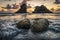 Dramatic clouds over sea stacks in Oregon and water splashing around rocks