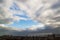 Dramatic cloudscape over the seaside city. Dark clouds surround the last spot of a blue sky in a daytime