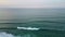 Dramatic cloudy marine panorama aerial view. Foamy ocean waves covering beach