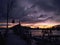 Dramatic cloudy nightscape with silhouette of boat house and dock at an empty marina during twilight hours