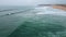 Dramatic cloudy seaside panorama aerial view. Foamy sea waves crashing at beach