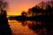 Dramatic and colorful sunrise over a Beautiful early winter landscape with a frozen river