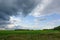 Dramatic countryside landscape with thunderclouds in the sky over a wheat field