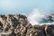 Dramatic crashing wave hitting rocks on the shore.