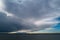 Dramatic dark clouds over the sea. With brighter clouds on the horizon looking like mountains