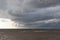 Dramatic dark clouds during sunset at sea