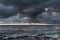 Dramatic dark clouds during sunset at sea