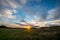 dramatic dark red clouds in sunset over countryside fields and forests