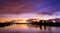 Dramatic dusk sky over the riverbank with colorful majestic orange sunlight clouds after sundown