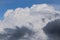 Dramatic epic big white fluffy storm cumulus clouds in blue sky background