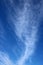 Dramatic feathery white clouds in blue sky