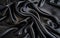 Dramatic folds and ripples of inky black satin fabric, exuding a sleek and mysterious allure with the shimmering textile