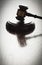 Dramatic Gavel Silhouette on Reflective Wood